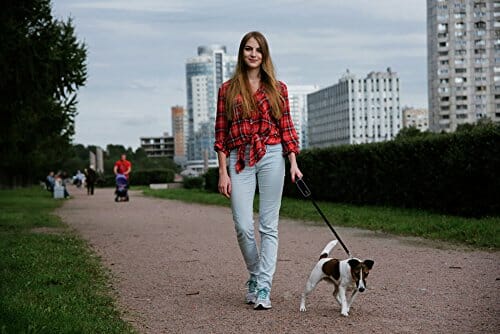 woman walking dog with retractable leash
