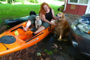 Woman on kayak with two dogs