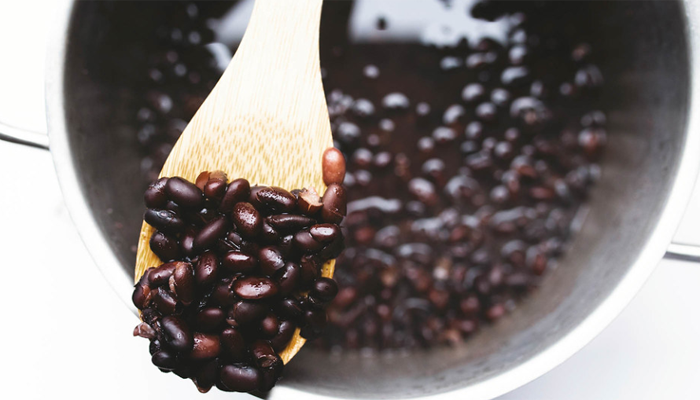 Black beans on a wooden spoon