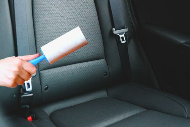 lint roller is used to catch loose hairs in a car seat